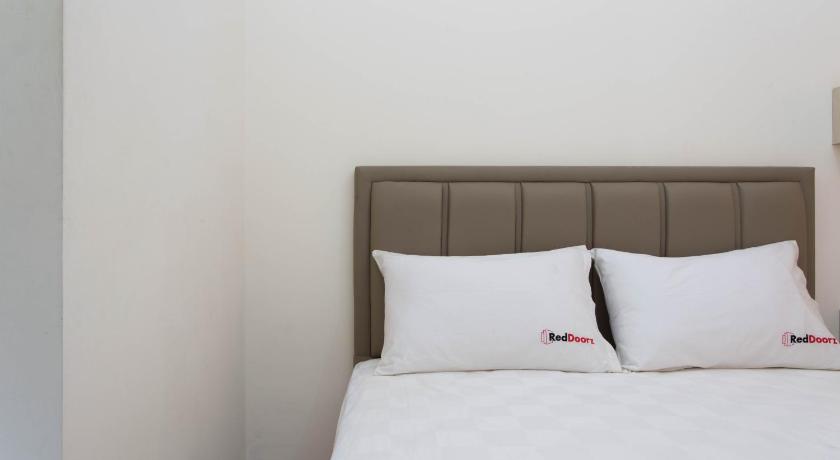 a white bed with a white comforter and pillows, RedDoorz Plus near Siloam Karawaci in Tangerang