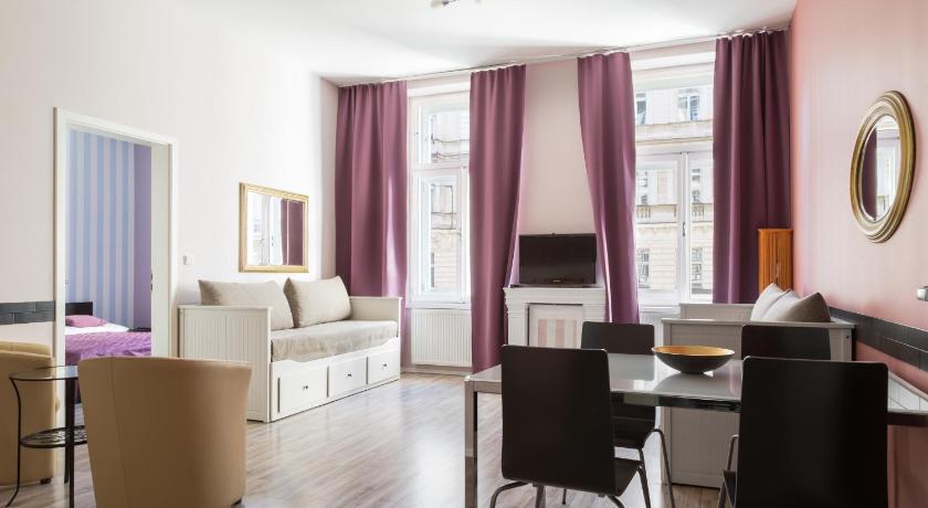 a living room filled with furniture and a large window, Royal Court Apartments in Prague