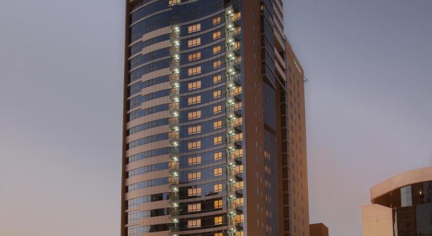 a tall building with a clock on it's side, Nour Arjaan by Rotana in Fujairah