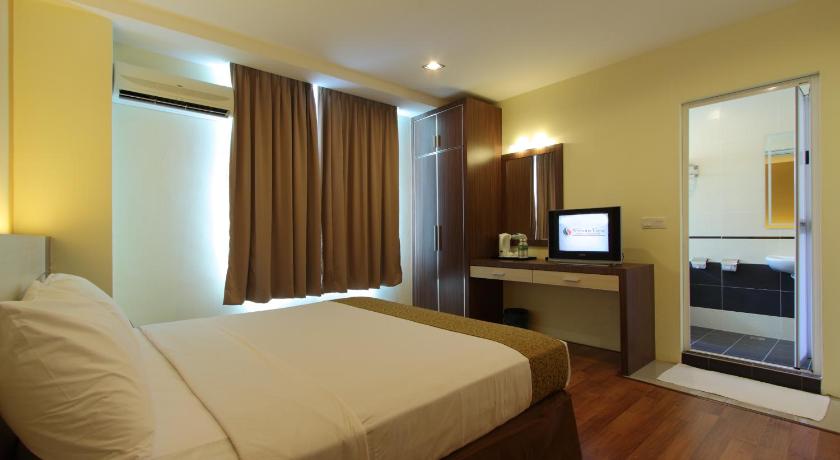 a hotel room with a large bed and a television, Seasons View Hotel in Kuantan