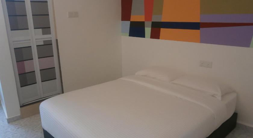a bed room with a white bedspread and a blue wall, F.M GUESTHOUSE in Kuantan