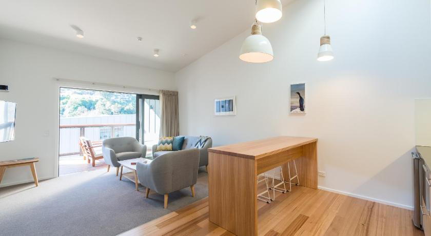 a living room with a wooden floor and a large window, Kaiteriteri Reserve Apartments in Motueka