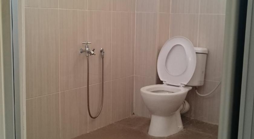 a white toilet sitting in a bathroom next to a shower, Homestay at 137 in Kuala Lumpur