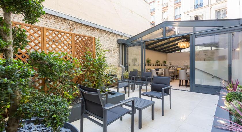 a patio area with chairs, tables and umbrellas, Jardin de Villiers in Paris