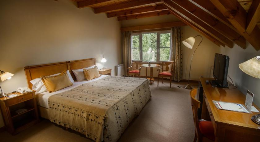 a bedroom with a bed and a dresser, Hotel Kosten Aike in El Calafate