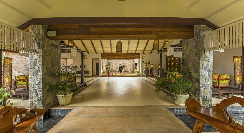 a walkway in a large building with many windows, The Windflower Resorts & Spa Coorg in Coorg