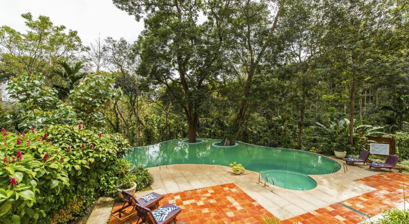 a green patio area with a bench and plants, The Windflower Resorts & Spa Coorg in Coorg