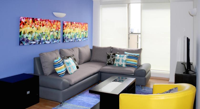 a living room filled with furniture and a blue couch, Puerta Alameda Suites Mexico in Mexico City