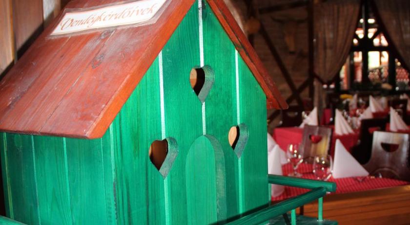 a green and white birdhouse with a red roof, Karikas Hotel in Hajduszoboszlo