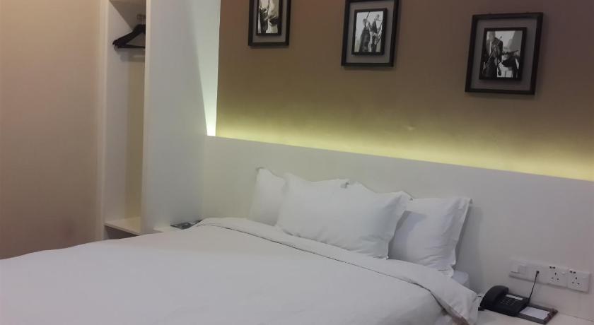 a hotel room with a bed and a lamp, Avida Hotel in Labuan
