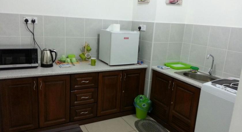 a kitchen with a sink, microwave, and dishwasher, Homestay KBCC in Kota Bharu