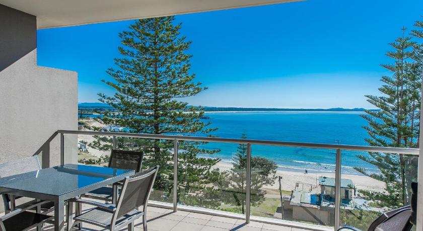a dining room with a balcony overlooking the ocean, Sandcastle Apartments in Port Macquarie
