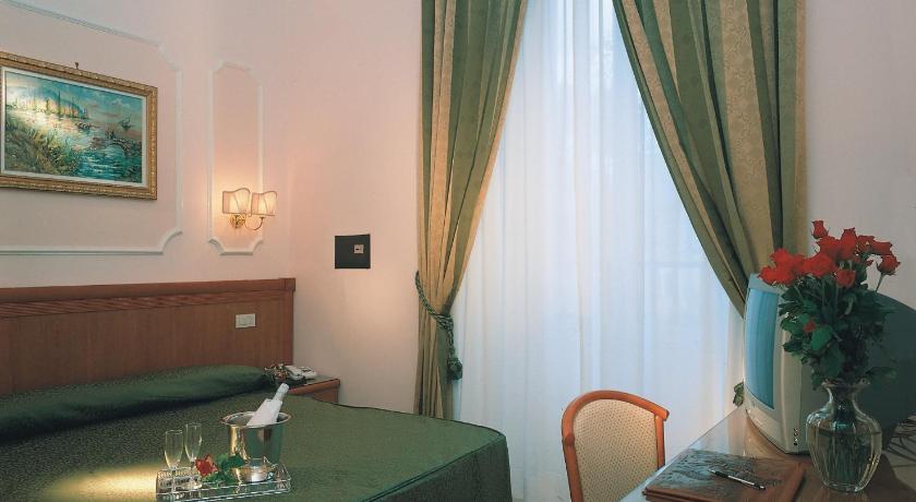 a room with a bed, a table, a lamp and a window, Hotel Philia in Rome