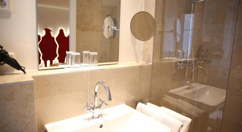 a bathroom with a sink, mirror and bath tub, Hotel Drei Raben in Nuremberg