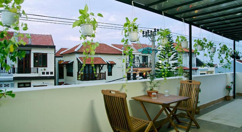 a patio area with a patio table and chairs, An Hoi Town Homestay in Hoi An