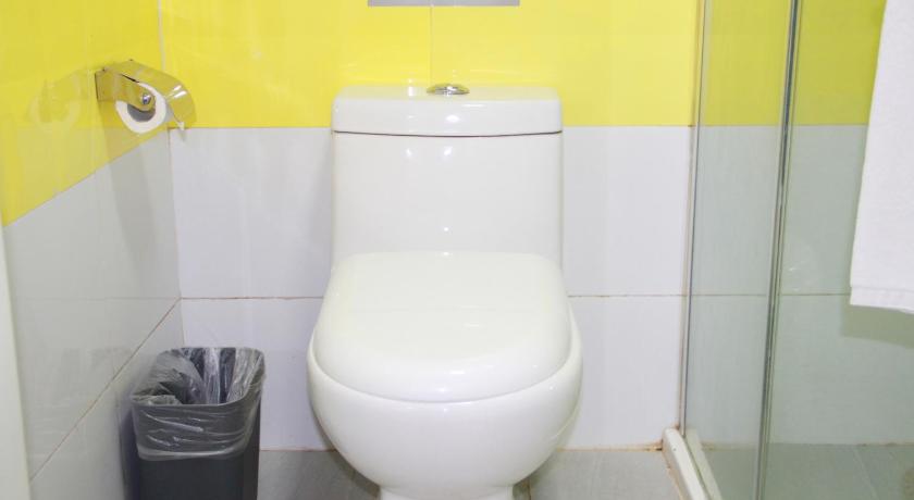 a white toilet sitting next to a toilet paper dispenser, 7 Days Inn Beijing South Railway Station South Square Yangqiao Branch in Beijing
