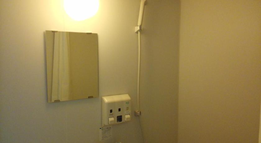 a bathroom with a light on and a mirror, Hotel Miyako Hills in Miyako