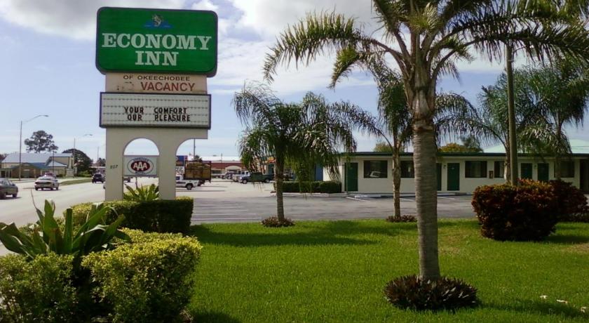 a palm tree in the middle of a grassy area, Economy Inn Okeechobee in Okeechobee (FL)