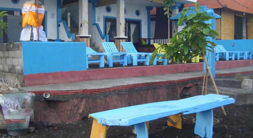 a blue bench sitting on top of a patio next to a building, De Adema Guesthouse in Bali