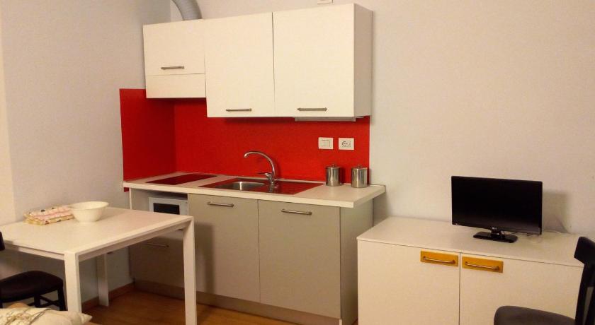 a kitchen with a white refrigerator and white cabinets, Luoghi Comuni Porta Palazzo in Turin