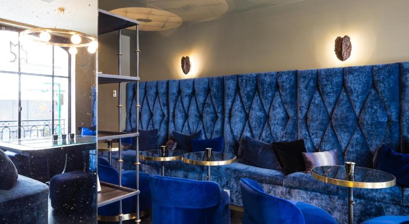 a living room with a blue couch and blue chairs, Monsieur Cadet Hotel & Spa in Paris
