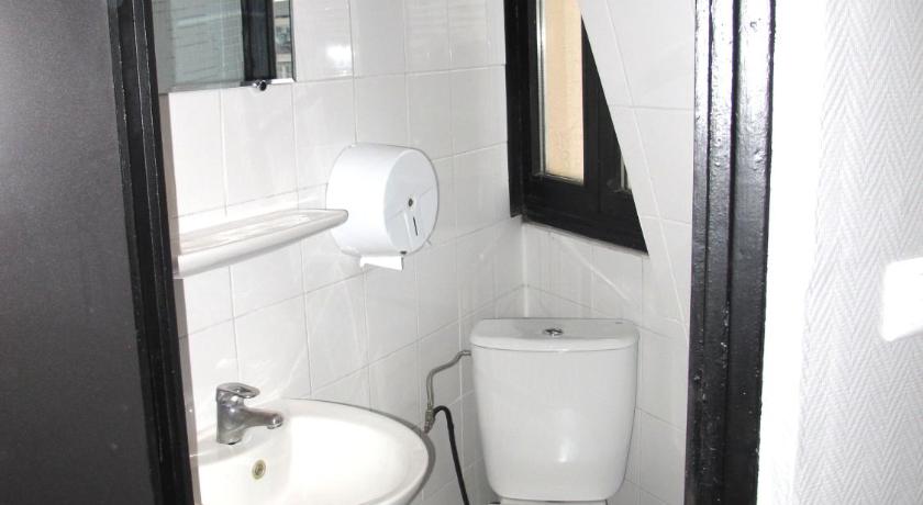 a bathroom with a toilet a sink and a mirror, Peace and Love Hostel in Paris