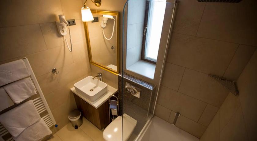 a bathroom with a toilet a sink and a bath tub, Pole Position Beach Hotel in Balatonlelle