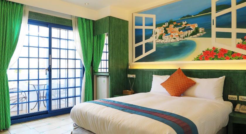 a bedroom with a bed, a window and a painting on the wall, Sin Sin Hotel in Kenting