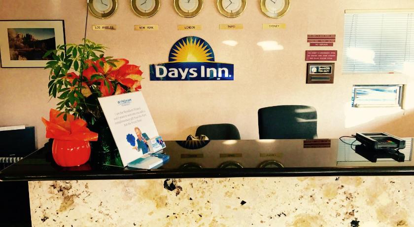 a desk with a clock on it and a sign on the wall, Days Inn by Wyndham Anaheim Near the Park in Los Angeles (CA)