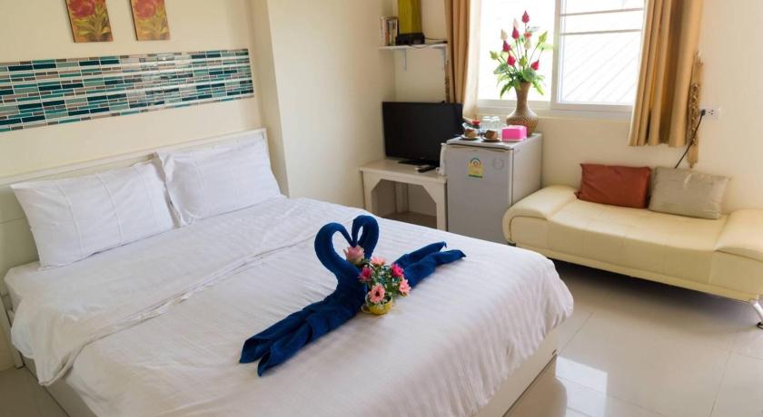 a bed with a white blanket and pillows on it, Lotus Suite Hua Hin in Hua Hin / Cha-am