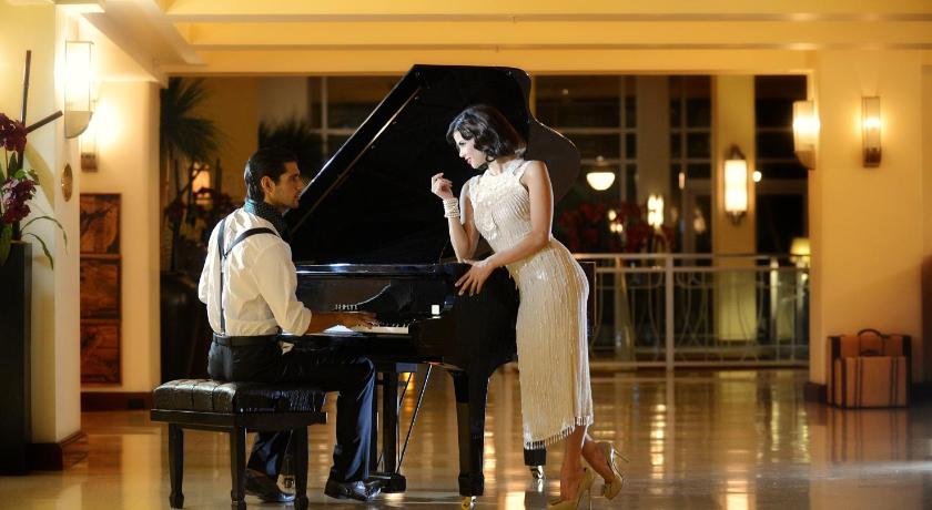 a woman and a man standing in front of a piano, The National Hotel, An Adult Only Oceanfront Resort in Miami Beach (FL)