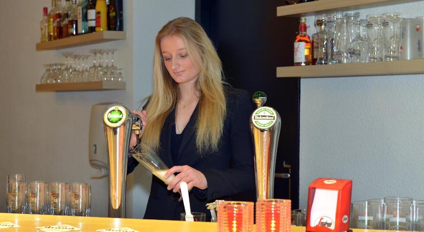 a woman holding a pair of scissors in front of a counter, Apart Hotel Randwyck in Maastricht