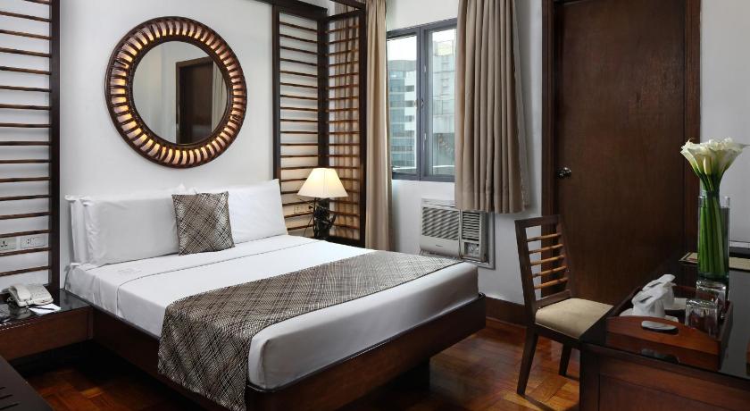 a bedroom with a bed and a dresser, Manila Lotus Hotel in Manila