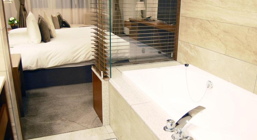 a bath room with a tub and a sink, Le Grand Kyu Karuizawa in Karuizawa