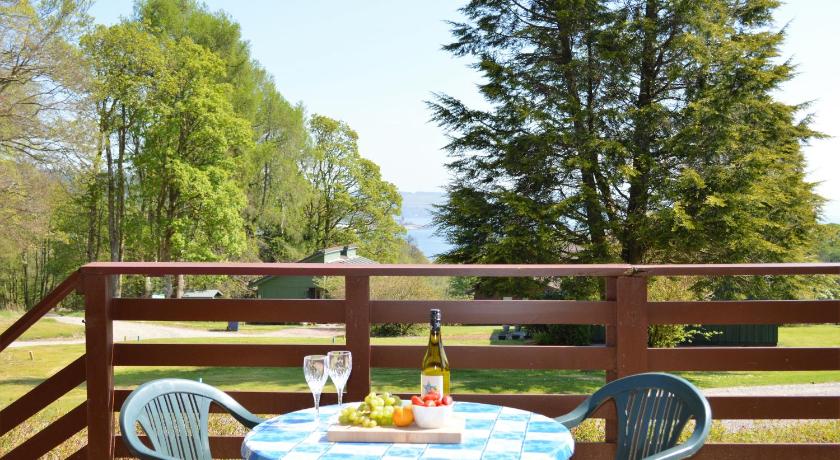 a table with a plate of fruit and a glass of wine, Loch View Lodge in Sandbank