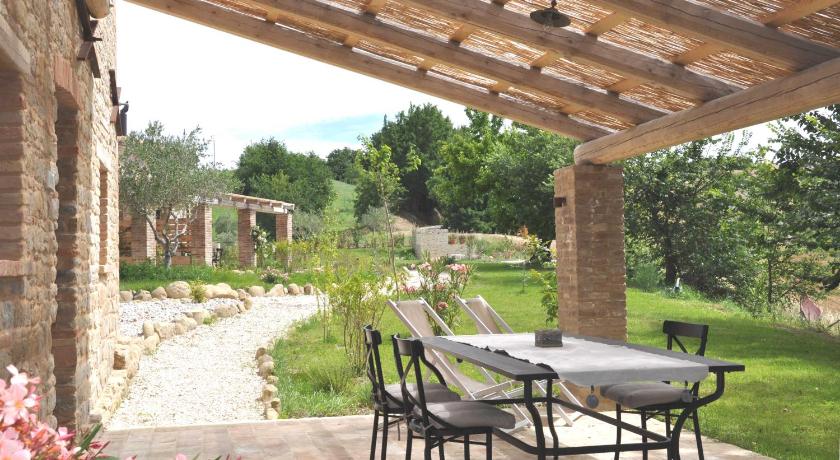 a patio area with a table and chairs, Borgo Farneto in Serra de' Conti