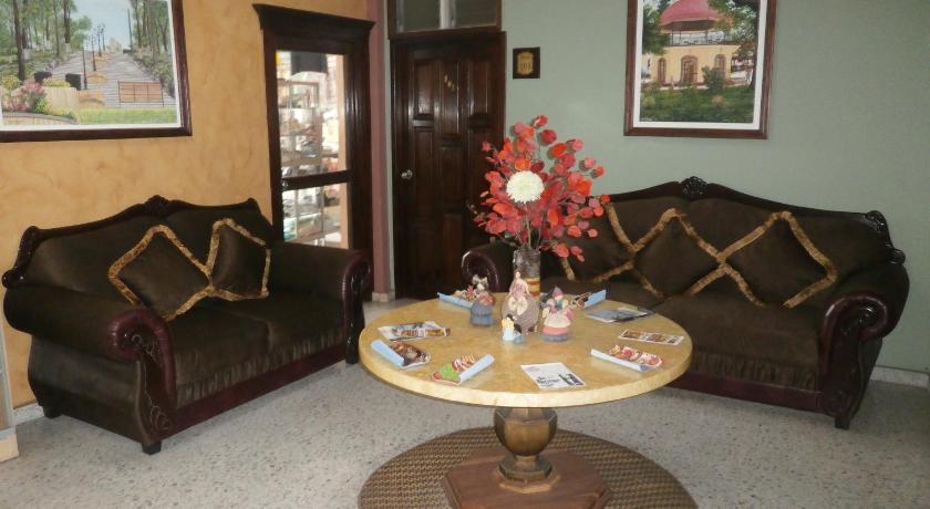 a living room filled with furniture and flowers, Hotel San Jorge in Santa Rosa De Copan