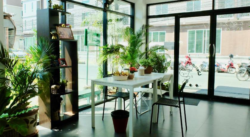 a living room filled with furniture and plants, We Inn in Bangkok
