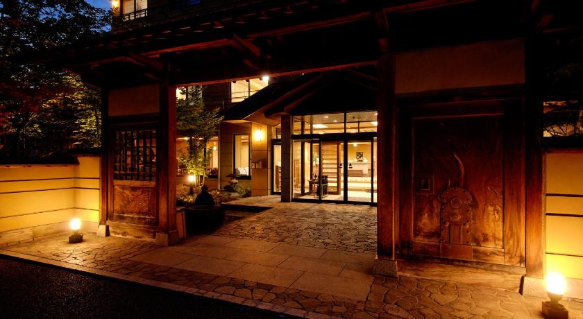 a room with a fire place and a clock on the wall, Shibu Hotel in Nagano