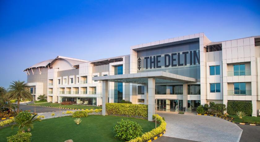 a large building with a large clock on the front of it, The Deltin Hotel in Daman