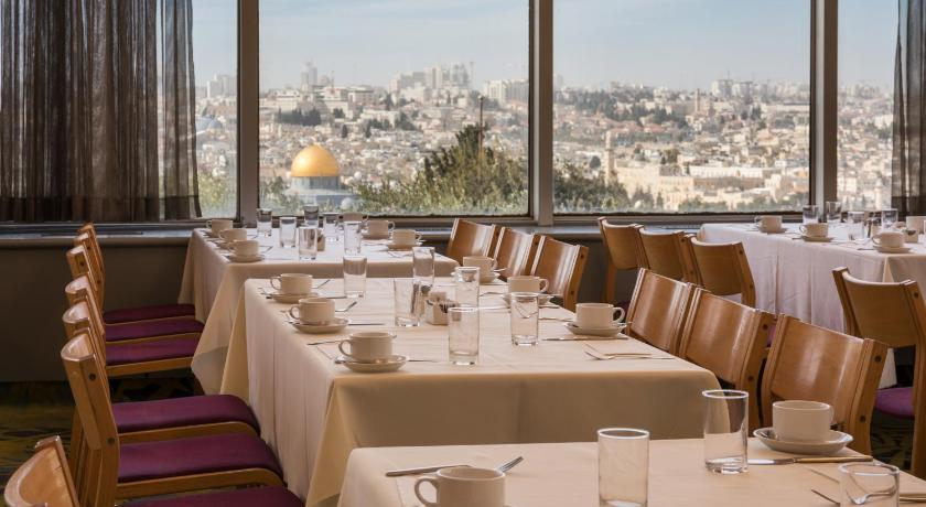a dining room table with chairs and tables, Seven Arches Hotel in Jerusalem