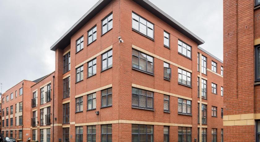 a large brick building with a clock on the side of it, Beautiful Apartments with Free Parking and Wifi in the Heart of Jeellery Quarter in Birmingham