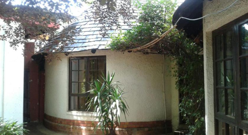 a house with a window and a plant in front of it, Rosebank Hostel in Johannesburg