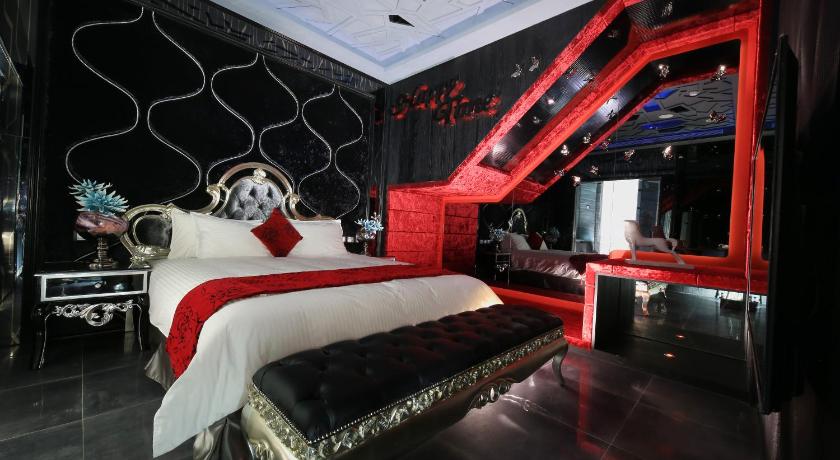 a hotel room with a bed and a night stand, Feifan Boutique Motel in Yilan