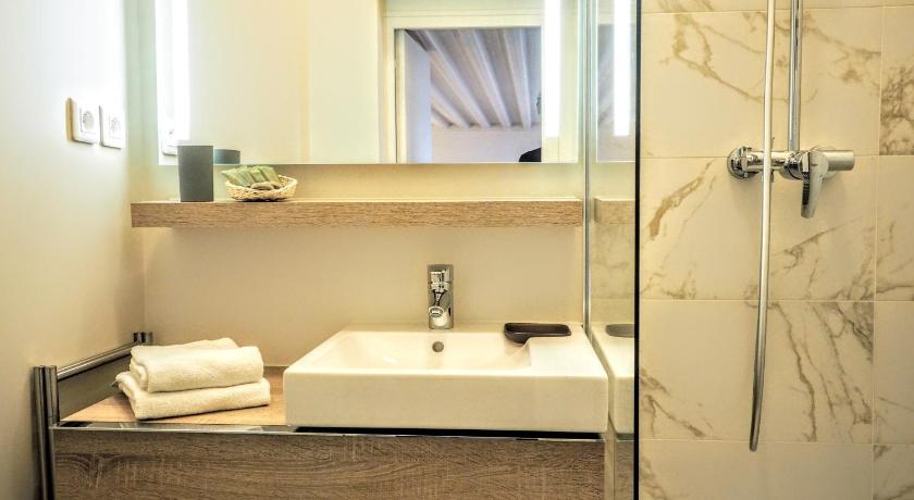 a bathroom with a tub, sink and mirror, Moliere ChicSuites in Paris