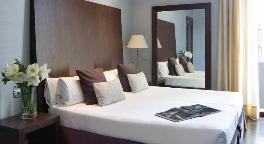 a hotel room with two beds and a mirror, Hotel Ramblas Internacional in Barcelona