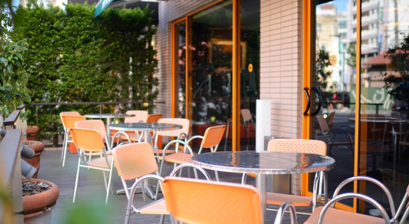 a patio area with tables and chairs and umbrellas, APA Hotel Maebashieki-Kita in Maebashi