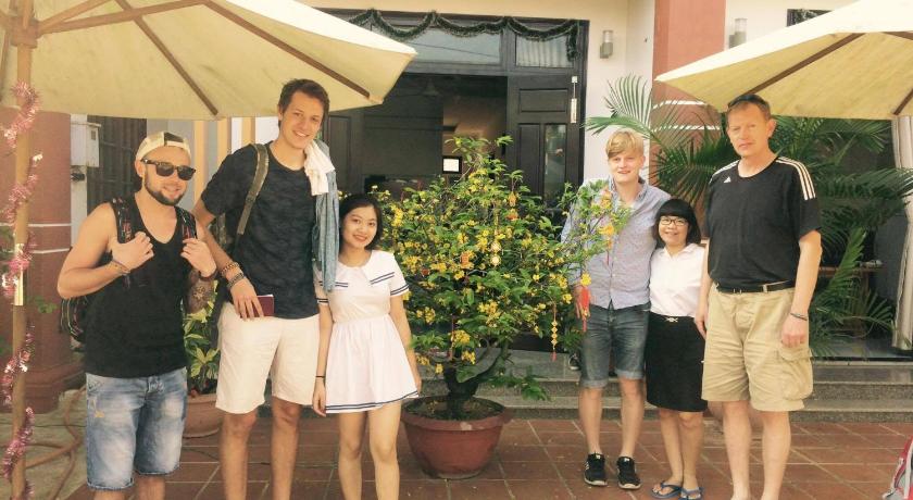 a family posing for a picture in front of an umbrella, Countryside Garden Homestay in Hoi An