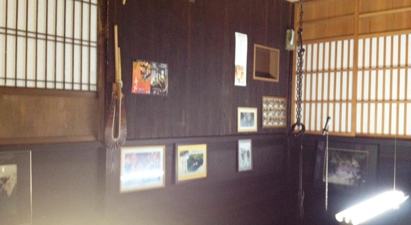 a room with a wooden wall and a painting on the wall, Minshuku Yomoshirou in Takaoka