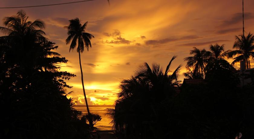 a sunset view of a city with palm trees, Phu Quoc Kim Bungalow On The Beach in Phu Quoc Island